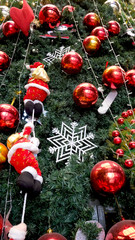 Christmas decoration. Hanging red balls, santa claus and Snowflake on pine branches and tree background.