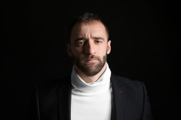 Portrait of stylish young man on dark background