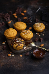 Homemade pumpkin muffins being decorated with chocolate