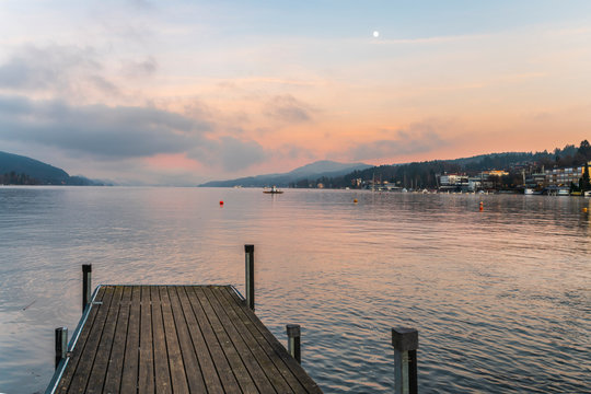 Last lights of the sunset in Velden. Reflections on the water and Christmas atmosphere. Austria.