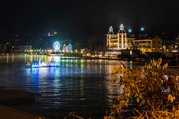 Fototapeta premium Velden am Woerthersee. Reflections on the water and Christmas atmosphere. Advent wreath and floating crib. Austria.