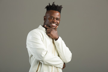handsome african man in a white jacket on a gray background