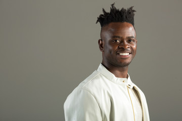 Obraz premium handsome african man in a white jacket on a gray background