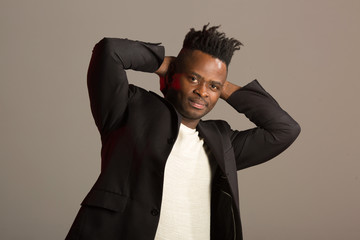 handsome african man in black suit on gray background