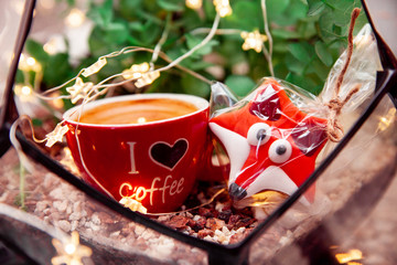 A cup of coffee lies with cookies behind a glass