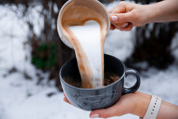 Barista pours milk from one cup to another