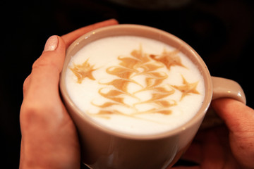 Girl holds a cup of Christmas coffee with a picture