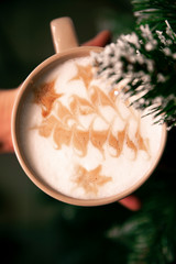 Cup with coffee on christmas tree background