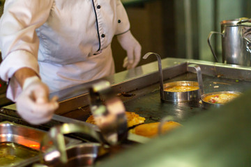 The chef bakes omelettes in the open kitchen of the hotel.