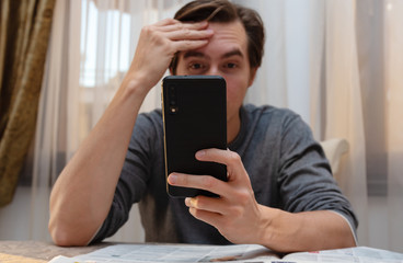 Surprised man with smartphone in hands.