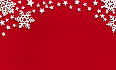 Christmas minimal mockup of white snowflakes and stars on red paper background. Flat lay, top view....