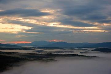 Fototapeta na wymiar Fog among the mountains at dawn.