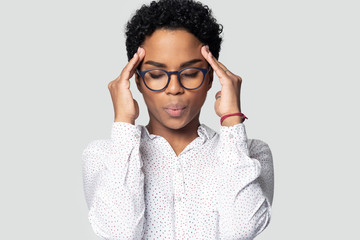 Tired millennial ethnic girl suffering for strong headache.