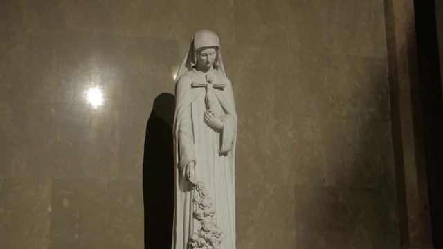 Woman statue catholic saint Therese of Lisieux by Beni Ferenczy crucifix in hands St. Stephen's Basilica in Budapest Hungary gimbal smooth camera movement