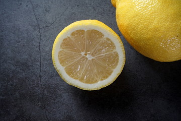 ripe yellow lemons on a dark concrete background