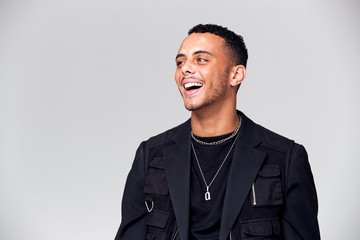 Studio Portrait Of Smiling Young Man With Skin Pigmentation Disorder Looking Off Camera
