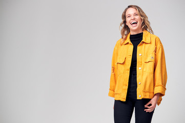 Studio Portrait Of Positive Happy Young Woman Laughing Off Camera