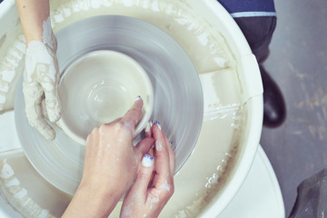 Women making ceramic pottery, concept for workshop and master class, four hands close-up, focus on potters, palms with pottery. Creative hobby concept. Earn extra money, side hustle