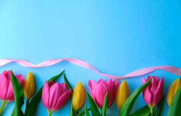 colourfull flowers with pink ribbon on blue background