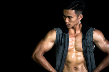 Muscle bodybuilder asia men posing muscle front on the black background. Body gym big chest and...