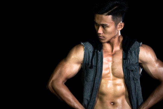 Muscle bodybuilder asia men posing muscle front on the black background. Body gym big chest and shoulder. Fashion style