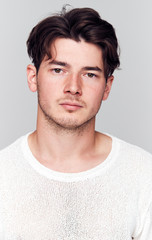 Obraz premium Studio Portrait Of Young Man With Serious Expression Looking At Camera