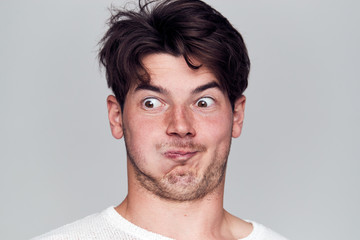 Obraz premium Head And Shoulders Studio Shot Of Man Pulling Faces And Smiling At Camera