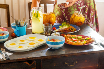 female hands over a table covered with healthy food terrace in the morning in Villa in tropical country