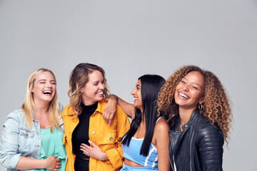 Group Studio Portrait Of Multi-Cultural Female Friends Smiling Into Camera Together
