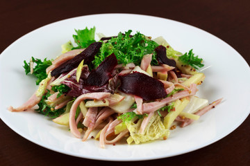 salad with meat, beets and vegetables in a plate	