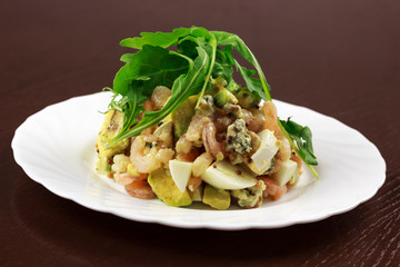 shrimp salad with egg and vegetables in a plate	