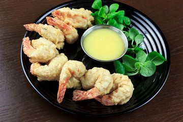 shrimp in batter with sauce and salad in a plate	