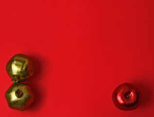 Metallic fruits on red background.