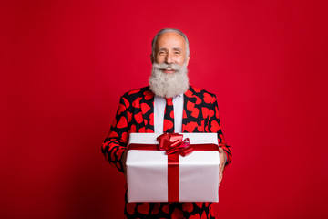Photo of funky mature guy amour cupid character role showing big gift box holiday courier wear stylish hearts pattern suit costume shirt tie isolated red color background