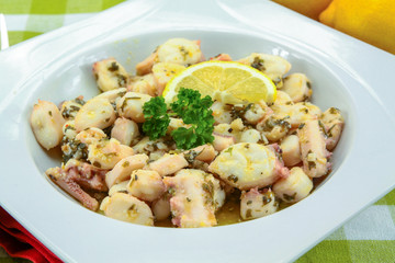 Octopus pieces cooked with garlic and parsley on a plate