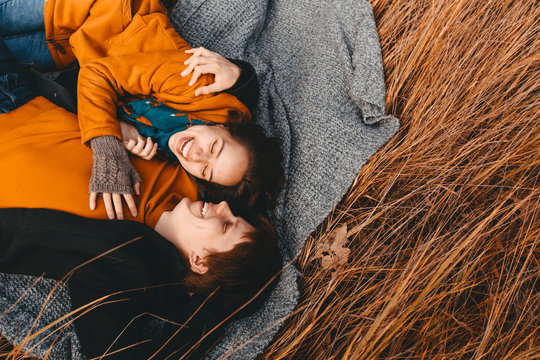 Young man and woman are lying and hugging in the autumn field.