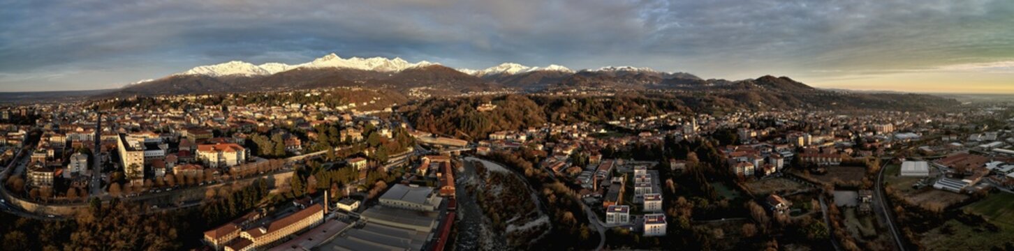 Aerial view of the city of Biella, with snow on the mountains