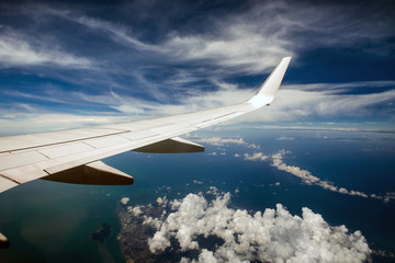Fototapeta premium Wing of airplane in cloudy sky