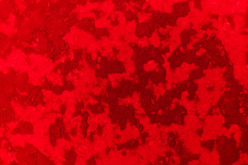 Fototapeta na wymiar Bright abstract texture of wet stucco on the wall, red color and its shades.