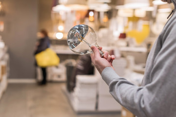 Man hand holding or selecting huge LED diode light bulb lamp in department store. Energy efficient...