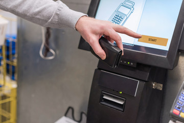 Man paying at the self-service counter using the touchscreen display and credit card. Isometric self-service cashier or terminal.