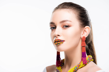 attractive girl in beaded accessories, with beads on lips, looking at camera isolated on white