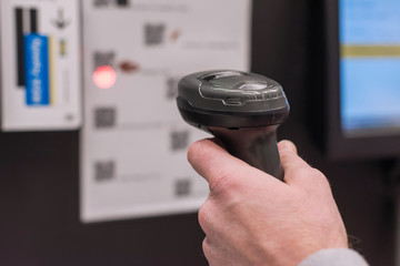 Customer with manual scanner of barcodes scans the scan discount card for buying in supermarket. self catering