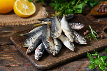 Fresh mackerel fish on wooden Board on brown wooden background - obrazy, fototapety, plakaty