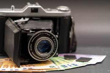 alte Kamera mit Speicherkarten auf Geldscheinen quer