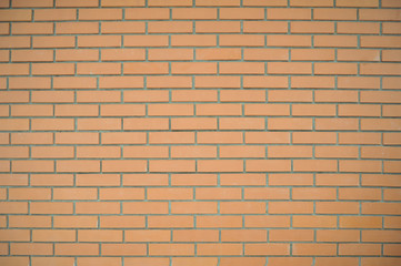 Brick wall of rectangular pale red bricks with gray seams. Background of a brick wall.