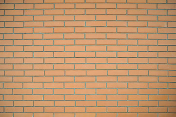 Brick wall of rectangular pale red bricks with gray seams. Background of a brick wall.