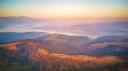 Aerial panorama of autumn mountains. Sunrise over mountain foggy valley