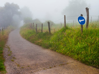 Señal de tráfico y valla entre la niebla en Ajo. Cantabria. España. Europa.