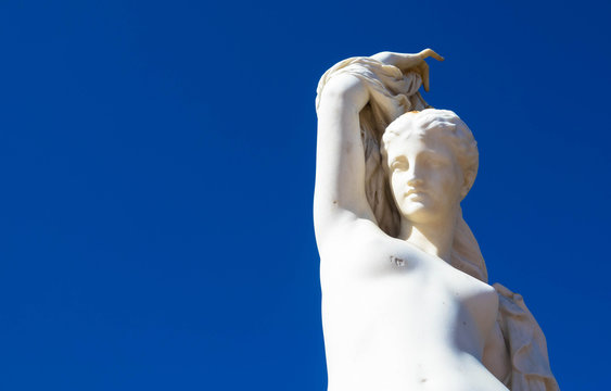 Statue einer nackten Frau vor blauem Himmel
